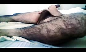 Hairy guy stroking his huge beefy cock