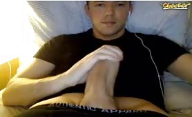 Cute young guy gropes his huge cock while chatting on his computer